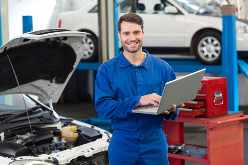 Mechanic using his laptop at the repair garage